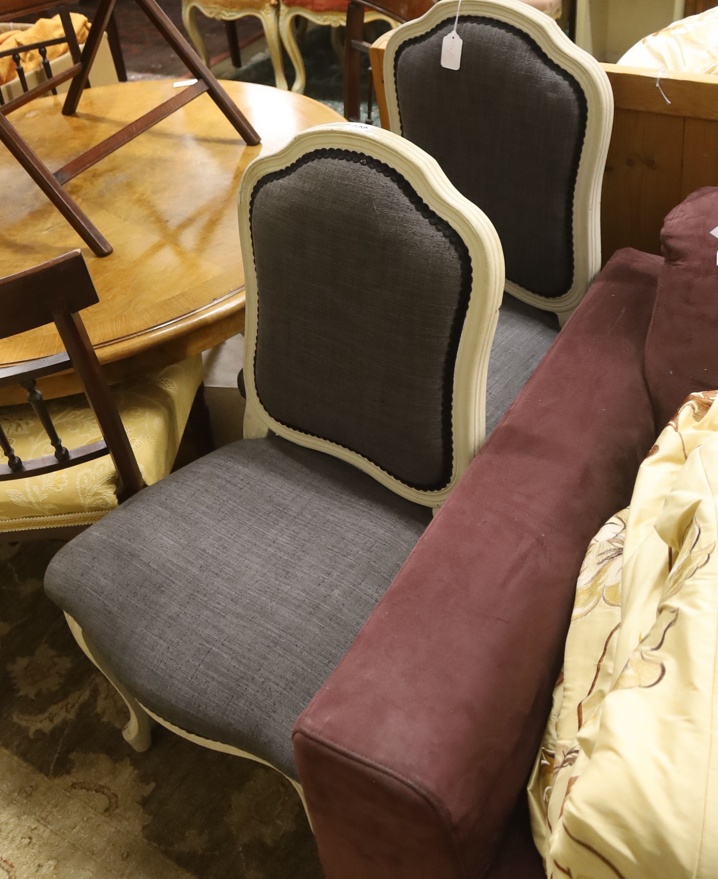 A pair of grey upholstered dining chairs